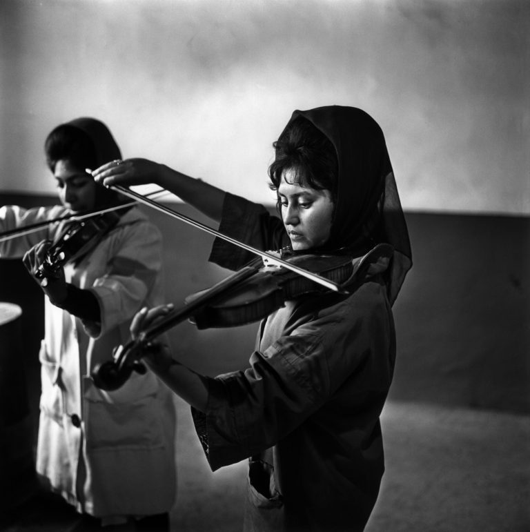 Pédagogie :leçon de musique.Ecole de musique de Kaboul (Afghanistan), fondée par l’Académie musicale de Vienne : leçon de violon donnée par l’enseignante autrichienne Mme Wenzlitzka.Photo, 1963